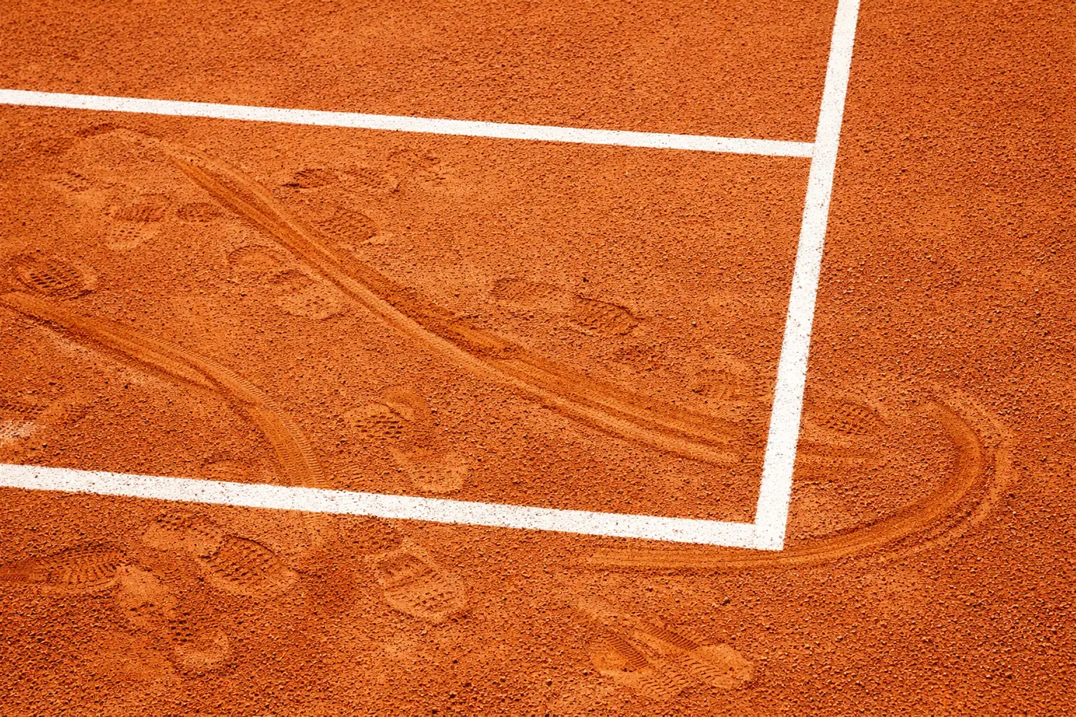 Court de tennis en terre battue avec lignes blanches bien visibles